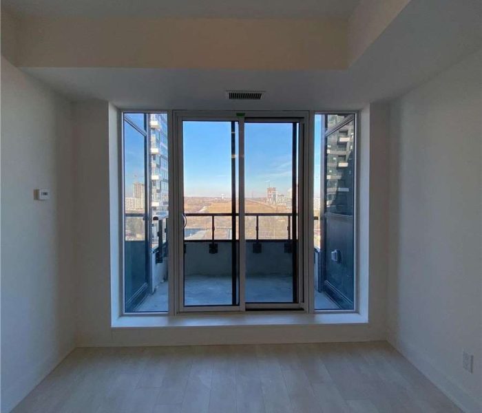 A room with a large window and a balcony.