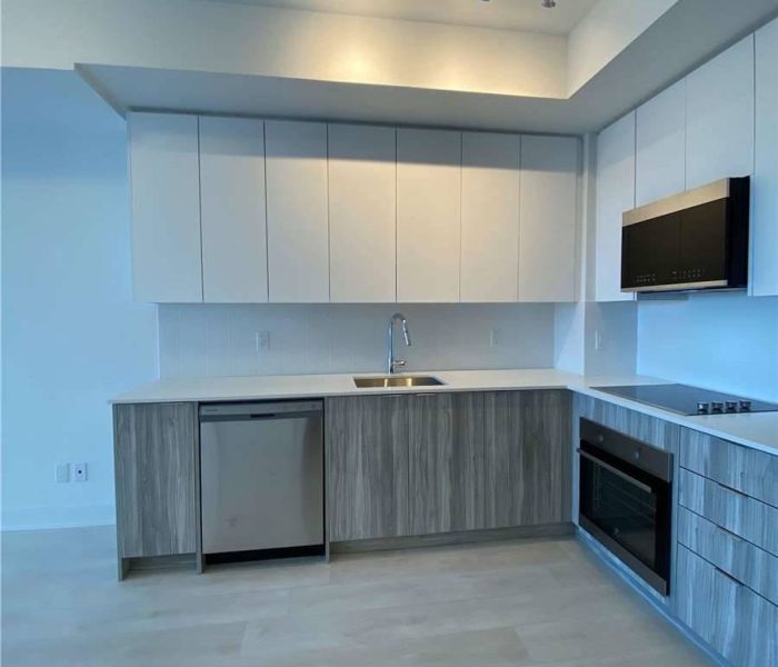 A kitchen with white cabinets and wooden floors.