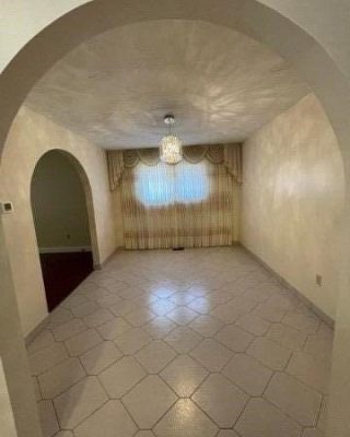 A room with a white tile floor and a large window.