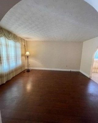 A living room with hard wood floors and white walls.