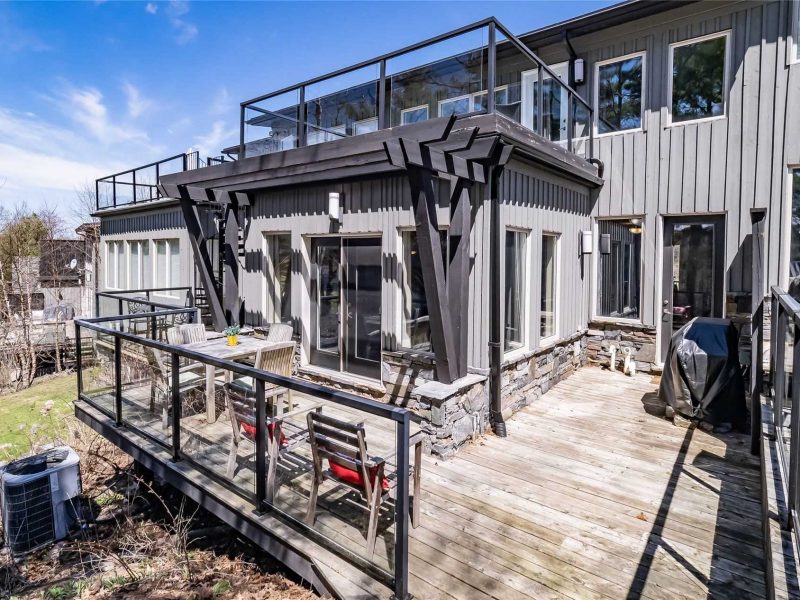 A large deck with a bench and chairs.