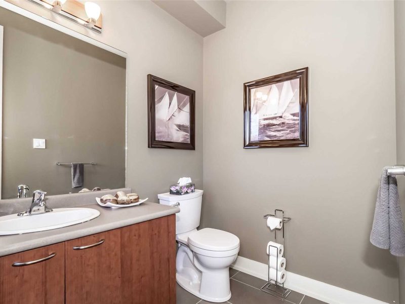 A bathroom with a sink, toilet and mirror.