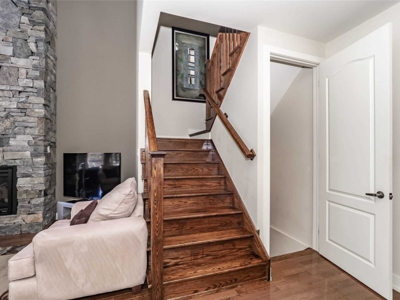 A wooden staircase with wood railing and handrail.