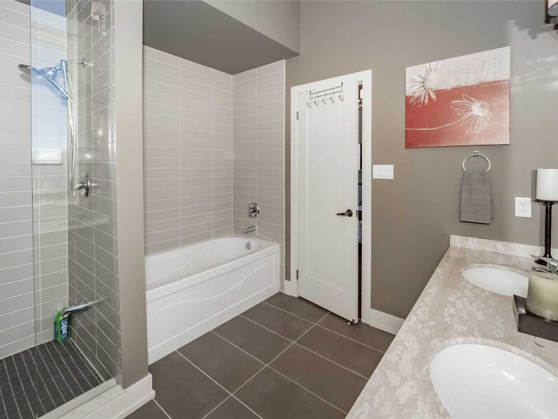 A bathroom with a tub, shower and sink.