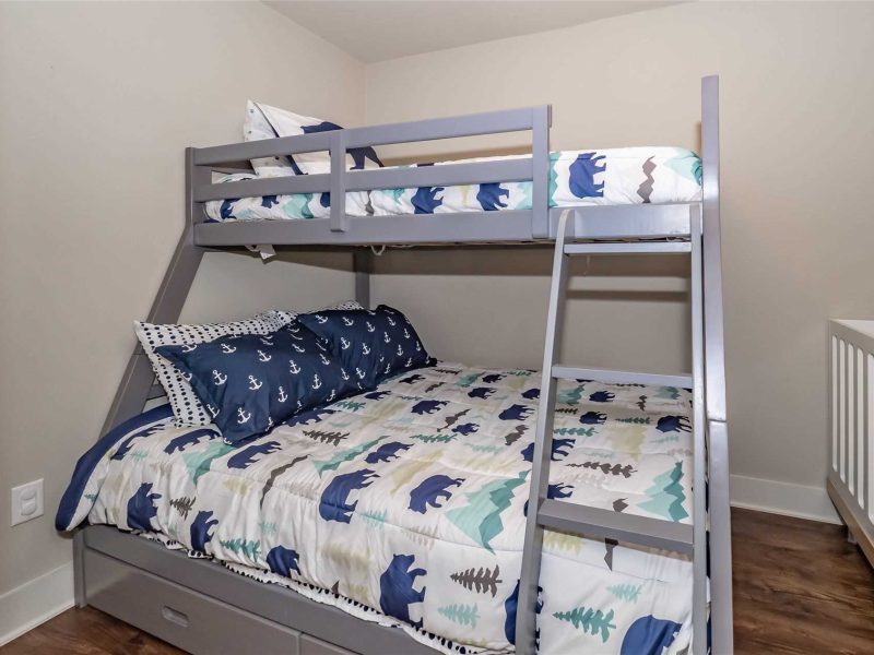 A bunk bed with two sets of stairs and one set of ladder.