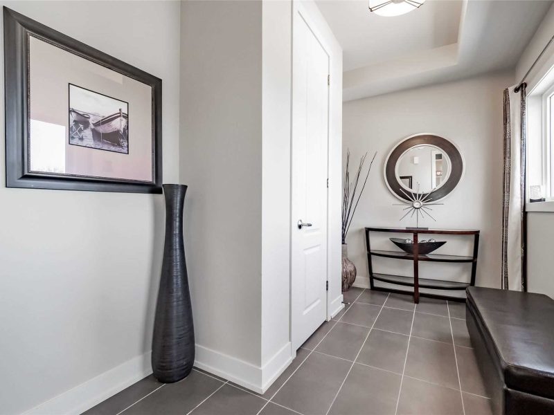 A hallway with a vase and mirror in it