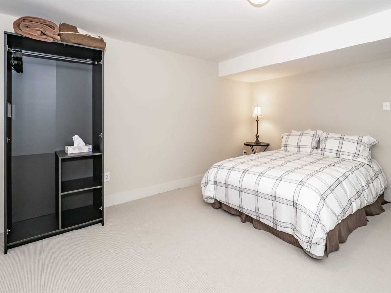 A bedroom with a bed, nightstand and television.