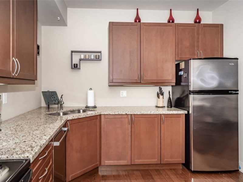 A kitchen with wooden cabinets and granite counter tops.